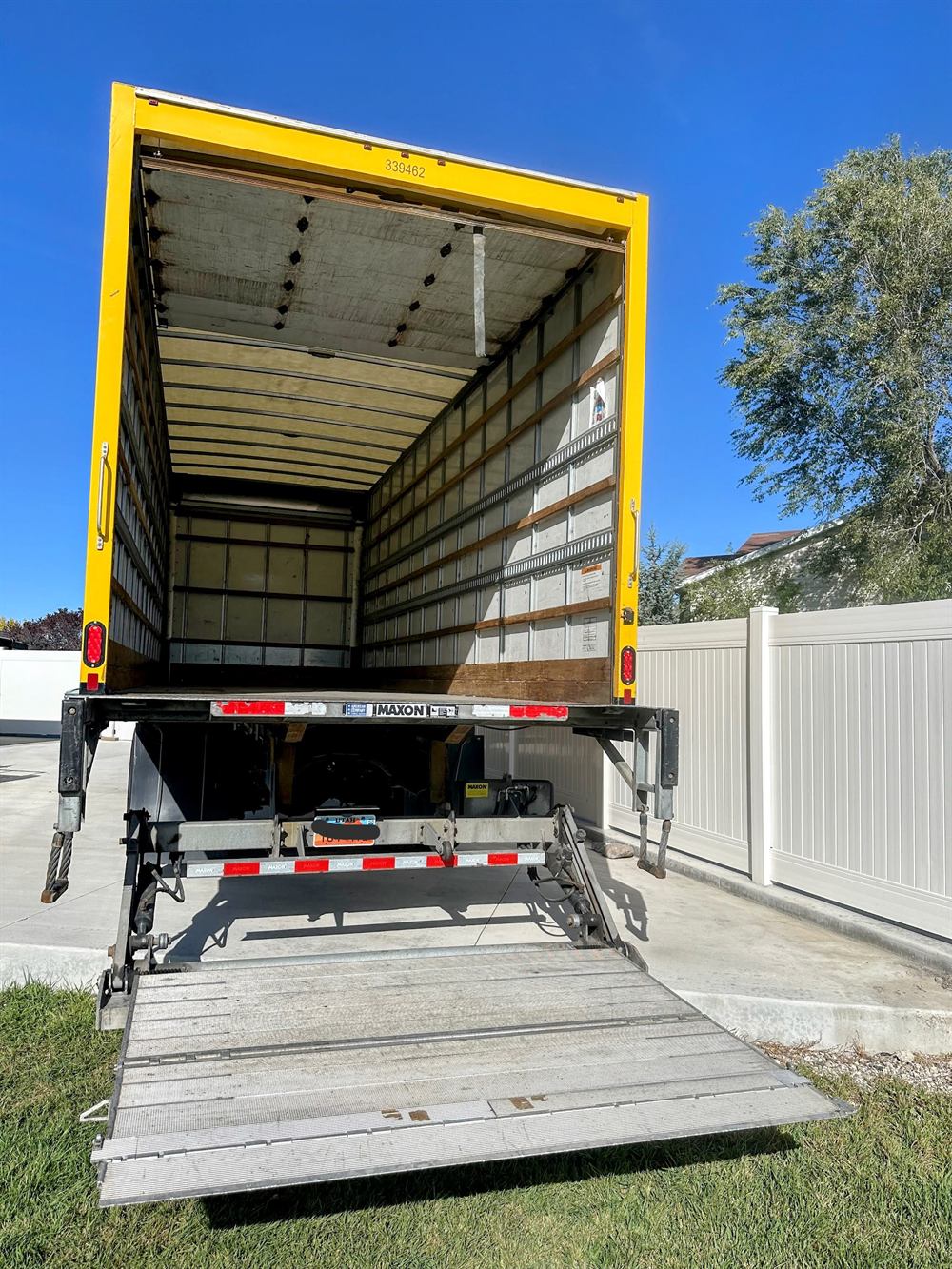 Bambara Logistics 26-foot box truck with its hydraulic liftgate lowered to the ground
